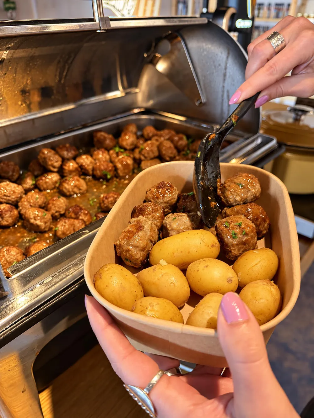 Köttbullar och potatis tas från lunchbuffén